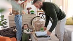 Family, help and parents with laundry to fold and their baby playing in the living room at home. Happy couple doing household clothing chore while bonding, talking and taking care of the child