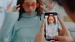 Influencer girl make video with phone, for social media post or fashion blog. Young curly hair woman, in fashion sunglasses and trendy clothes, blow kiss to online followers on the internet or app