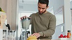 Healthy man, smoothie maker and vegan diet with an asian man preparing a health shake with fruit in the kitchen at home. Blender, nutritionist food and detox drink recipe with fresh ingredients