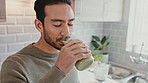 Man drinking a green juice for health, wellness and organic diet in a kitchen at home. Happy guy with healthy, weight loss and natural lifestyle enjoying smoothie for breakfast, energy and nutrition.