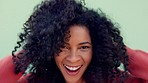 Black woman, play with hands in natural hair and laugh against green background in closeup portrait. Zoom of excited hair care model, show smile and touch healthy afro, against mint backdrop or wall