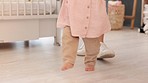 Walking, learning and development with a baby taking her first steps with mom in the bedroom of their home. Children, family and mother with the feet of a little female child and her parent inside