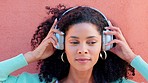 Music, headphones and face of a happy black woman listening to radio, song and sound against a wall background. African female head in wireless happiness, excitement and fun audio playlist outdoors