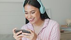Headphones, smartphone and woman on video call, audio or live streaming app in bedroom for networking online. Gen z teenager girl with cellphone, home wifi and virtual conversation on social media