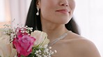 Rose, wedding and bride looking happy while posing for bridal pictures in a room, excited and smelling bouquet. Celebration, commitment and asian woman enjoying the morning of her special day