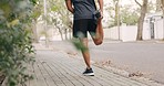 A health, fitness and athlete man training, exercise and stretching outside on sunny day. Healthy, strong and male runner doing exercise warm up with running sneakers outdoors for workout practice. 