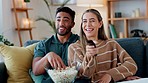 Young couple watching tv, movies and media on subscription streaming service in relax living room with popcorn at home. Smile, relax and happy people connect to cable television show together