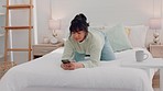 Bed, phone and woman text and relax in her a bedroom, happy and cheerful while social media. Communication, internet and home entertainment by black female enjoy online conversation and subscription