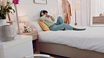 Woman, music and bed listening with headphones enjoying audio track and relaxing at home. Female singing and chilling with wireless headset lying in bedroom happiness for songs or streaming playlist
