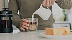 Coffee, dairy and milk pouring for breakfast drink in house kitchen to prepare strong cup of fresh plunger caffeine. Man hands, glass and morning of warm french press beverage to enjoy cappuccino