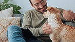 Happy man stroke with dog on sofa in home living room relax and bonding together for fun, care and happiness. Young asian male smile and love his loyal animal, puppy or pet on couch in house lounge
