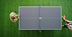 Employees play table tennis in office break room for fun, recreation and energy while working in creative startup company. Above ping pong table, business men game together and relax in team building