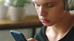 Headphones, music and search with man and phone to relax while streaming internet content for social media, podcast or radio. Digital, technology and app with young guy listening and scrolling online