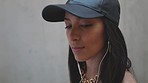 Music, urban and woman with earphones in streetwear dancing to song. Dance, style and street fashion girl listening radio streaming service. Enjoy and relax with headphones and listen to track online