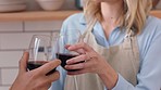 Red wine, cheers and couple in kitchen cooking dinner or food together with love and celebration. Fine dining, luxury and alcohol drink glasses with man, woman or social people celebrate in a home