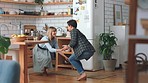 Dance, couple and love with a man and woman having fun together in the kitchen of their home. Freedom, laugh and carefree with a young male and female dancing with joyand bonding in their house