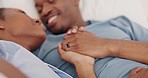 Love, black couple and in bedroom with kiss, holding hands and bonding for relationship, embrace and happy together. Romance, man and woman being loving, smile and romantic for marriage joy in bed.