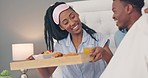 Breakfast, bed and black people couple with healthy food for morning nutrition, wellness and eating together in bedroom. Food fruits, croissant and orange juice with happy woman and african man kiss