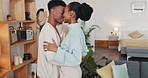 Kiss, hug and African couple with smile in the living room of their house together. Happy, young and black man and woman with affection, kissing and hugging for love in marriage in their home