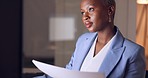 Documents, business and black woman working on an email, portfolio and startup proposal for a company. Night, review and African entrepreneur typing paperwork on an online project report on computer