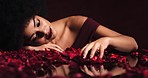 Rose petals, black woman and sexy female with love or sexual desire in a dark, seductive and sensual mirror studio. Romance, luxury and passion for valentines day, anniversary and romantic date