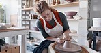 Pottery, woman artist and clay mold with wheel spinning in creative class, studio and workspace hobby. Creativity, female sculptor or girl student shape art, sculpting and ceramic design in workshop.