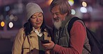 Night, phone and senior couple in the city on a holiday in the Philippines and talking about a meme on the internet. Elderly man and woman reading on a smartphone during vacation in the dark street