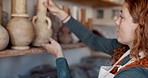 Pottery, shelf and small business owner woman in her startup retail store with hand sculpture product design for sale. Art, creative and designer, seller or entrepreneur artist working in a workshop