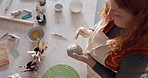 Hands, pottery mud or sculpture artist with clay cup, mug or vase in art studio, product manufacturing workshop or small business. Top view, woman and sculpting tool in creative shop or ceramic class