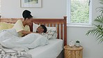 African couple, kiss in bed and happy relax together bonding in morning hotel bedroom under blankets. Young husband and wife smile, care and happiness while kissing with love on vacation or honeymoon