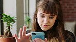 Social media, phone and creative designer reading an email on a mobile app while working at a marketing startup. Face of an employee typing on a chat on the internet with smartphone in an office