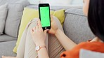 Woman, phone and green screen with mockup space, digital marketing and brand advertising on a sofa. Young female with mobile smartphone for social media, streaming and watching movie on app online