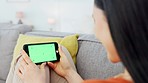 Smartphone, green screen mockup and woman on sofa relax at home with smile watching social media video in modern Tokyo Japan apartment. Asian girl, internet online and using 5g wifi mobile connection