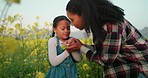 Flowers, child and mother cold in field in the countryside of Australia for calm, peace and adventure. Girl and her mom in  a nature park or garden with plants for happiness during winter together