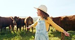 Nature, summer and girl in field with cows, happy little dairy farmer on grass. Sustainability, farming and a child with smile at green outdoor animal farm, happiness and grazing livestock in summer.