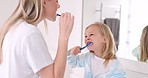 Toothbrush, mother and girl cleaning their teeth in the morning in the bathroom of their family home. Happy, bond and mom doing a dental hygiene routine for health with oral products with her child.