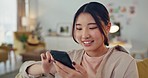 Asian woman, phone and social media with smile for communication relaxing on living room sofa at home. Happy Chinese female smiling for texting, chatting or browsing connection on mobile smartphone