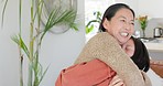 Asian mother, hug and child in house or family home living room in love, trust or security for birthday or mothers day celebration. Smile, happy and bonding mom, parent or woman in embrace with girl