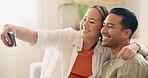 Selfie, smartphone and asian couple in living room for home photography, social media update or blog post about life together. Happy people on sofa in cellphone portrait for online memory or gallery