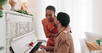 Christmas, piano music and couple singing festive holiday song, having fun and enjoy bonding quality time together. Love, smile and happy black woman and man play musical instrument and celebrate 
