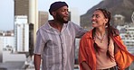 Comic, communication and interracial couple walking in the city, talking and on a date together. Happy, smile and black man and woman in a funny, comedy and crazy conversation while on a walk