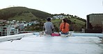 Couple, city rooftop and relax together with love, friendship and romance during a sunset picnic. Urban friends, freedom and peace talking on lunch date in Cape Town South Africa cityscape background