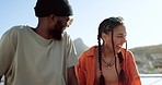 Love, couple and rooftop with man and woman talking, relax and bond while enjoying view of the city at sunset, fun and trendy. Summer, friends and balcony bonding by interracial guy and lady laughing