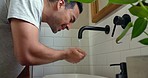 Man washing face in home bathroom, water splash and  body care, skincare morning grooming of wellness, healthy lifestyle and beauty. Young guy facial cleaning at faucet, personal hygiene or wellbeing