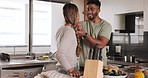 Food, couple and cooking in a kitchen by man and woman prepare salad, taste and embrace in their home together. Love, eating and interracial couple bond, relax and enjoy preparing healthy vegan meal