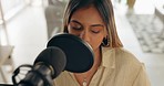 Singer, music and creative woman recording or live streaming in professional musician studio. Young female artist, working to create song or produce audio podcast on microphone at production company