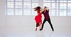 Dance, salsa and couple in dancing studio training together to music for a performance, show or ballroom. Energy, love and dancer woman with partner learning to tango or samba moving with creativity