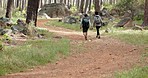 Hiking, adventure and couple walking in nature for fitness, exercise and health on path forest with trees for fun workout. Man and woman with backpack travel in woods together for healthy trekking