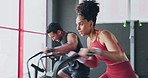Determination, fitness and endurance with couple cycling in gym together for strength and stamina. Active, fit and bike cardio with african american friends cycle and ride for competitive exercising 