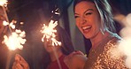 Young diverse friend group happy smiling holding sparkler having fun at party